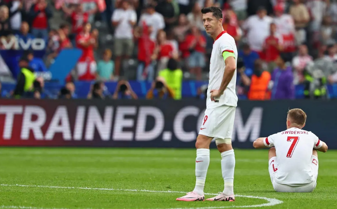 El delantero polaco Robert Lewandowski (I) y Karol Swiderski se lamentan tras la segunda derrota de Polonia en el torneo tras el partido del grupo D que han jugado Polonia y Austria en el Ol&iacute;mpico de Berl&iacute;n, Alemania. EFE/EPA/HANNIBAL HANSCHKE
