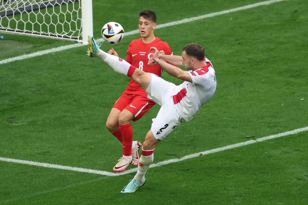 El georgiano Otar Kakabadze (d) despeja el bal&oacute;n ante el joven jugador de Turqu&iacute;a Arda G&uuml;ler en Dortmund, Alemania. EFE/EPA/FRIEDEMANN VOGEL