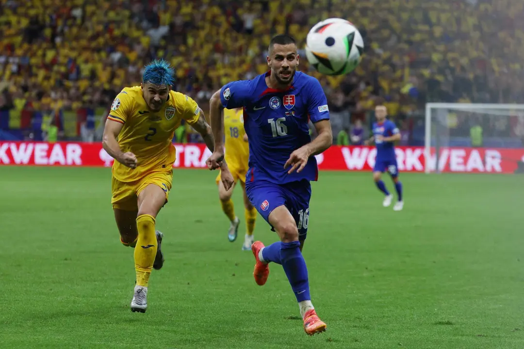 El defensa eslovaco David Hancko (c) y el rumano Andrei Ratiu buscan el bal&oacute;n durante el partido del grupo E que han jugado Eslovaquia y Ruman&iacute;a en Fr&aacute;nkfort, Alemania. EFE/EPA/MOHAMMED BADRA