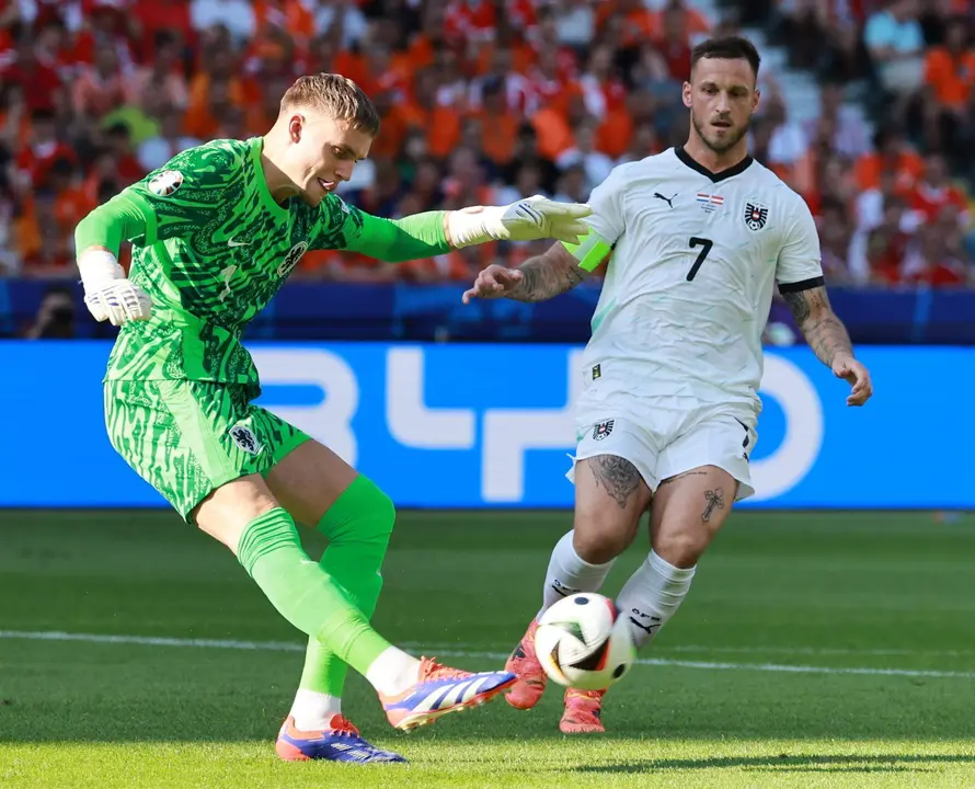 El portero neerland&eacute;s Bart Verbruggen (L) sufre la presi&oacute;n del delantero austriaco Marko Arnautovic en Berlin. EFE/EPA/CLEMENS BILAN