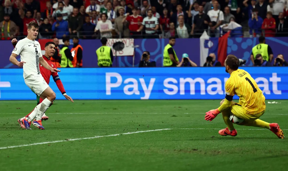 El portero esloveno Jan Oblak (d) evita el gol de Cristiano Ronaldo en los &uacute;ltimos minutos del partido de octavos de final entre Portugal y Eslovenia en Fr&aacute;kfort, Alemania.EFE/EPA/ANNA SZILAGYI