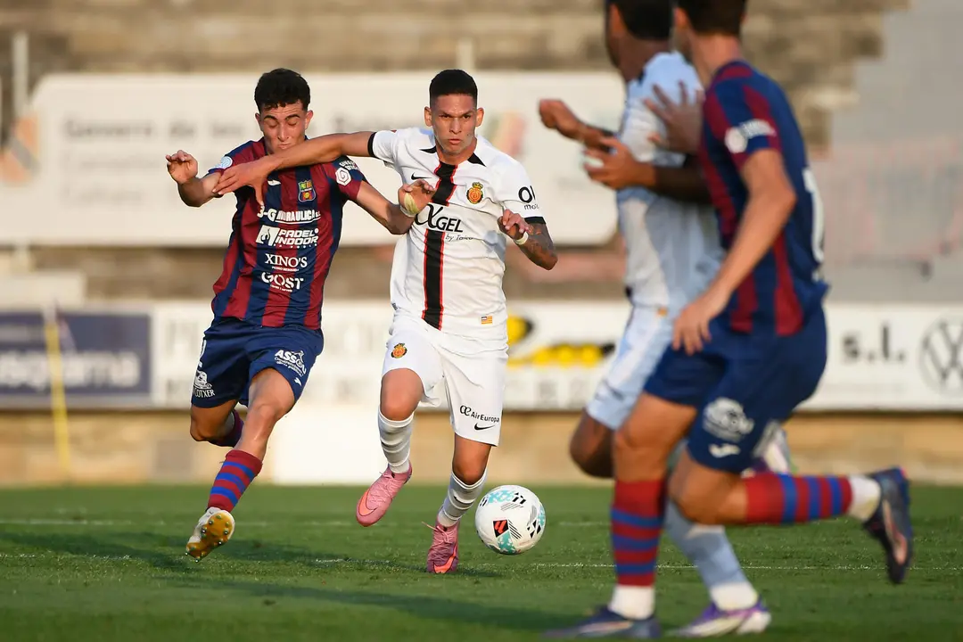 El centrocampista colombiano del RCD Mallorca Daniel Luna (2i) se escapa del defensa de la UD Poblense, durante el partido amistoso de f&uacute;tbol que UD Poblense y RCD Mallorca disputan este mi&eacute;rcoles en Sa Pobla. EFE/MIQUEL A. BORR&Agrave;S