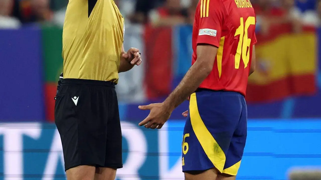 Referee Slavko Vincic (L) muestra amarlla a Rodrigo Hern&aacute;ndez, centrocampista de la selecci&oacute;n espa&ntilde;ola en Gelsenkirchen. Alemania. EFE/EPA/CHRISTOPHER NEUNDORF