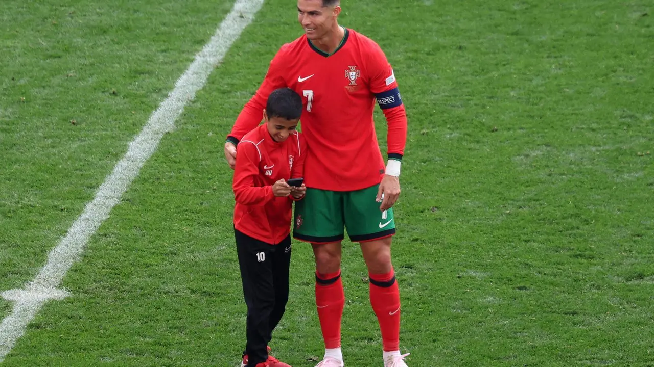 El jugador portugu&eacute;s Cristiano Ronaldo abraza a un ni&ntilde;o en el campo durante el partido de f&uacute;tbol del grupo F de la Euroco&agrave; 2024 entre Turqu&iacute;a y Portugal, en Dortmund, Alemania, .EFE/EPA/CHRISTOPHER NEUNDORF