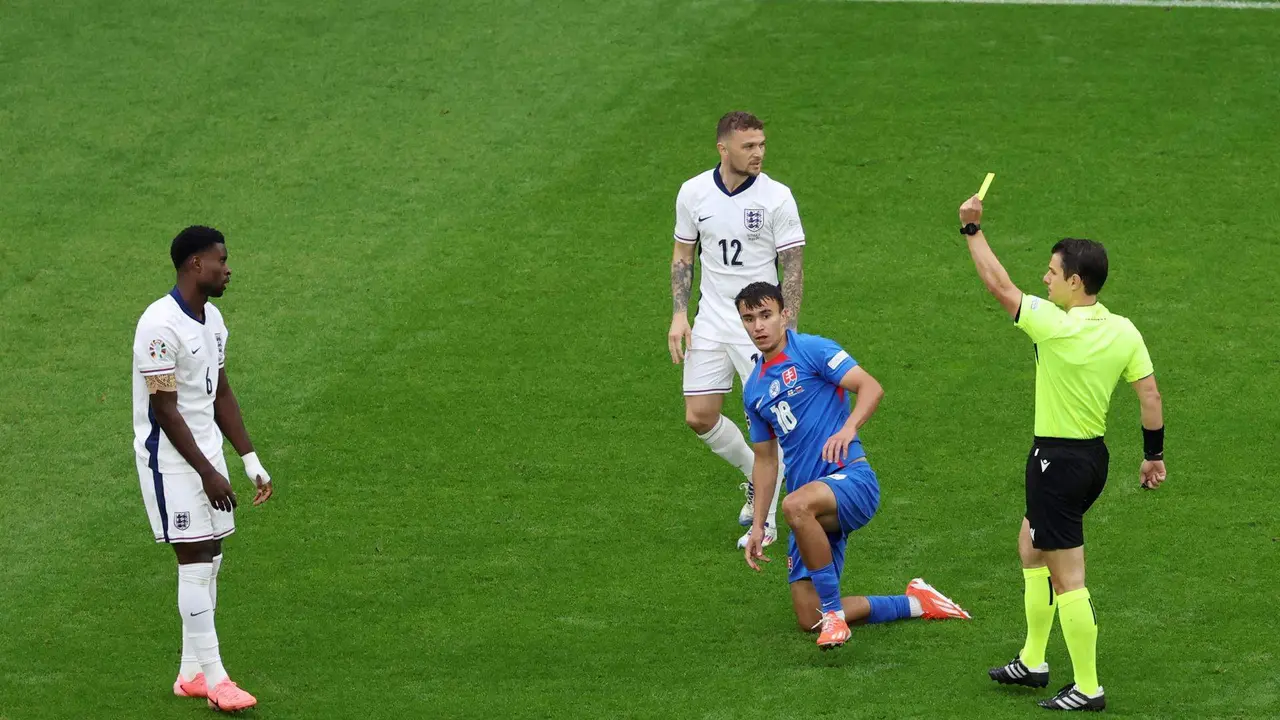 El &aacute;rbitro Umut Meler (d) muestra amarilla al defensa Marc Guehi durante el partido de octavos de final que han jugado Inglaterra y Eslovaquia en Gelsenkirchen, Alemania. EFE/EPA/GEORGI LICOVSKI